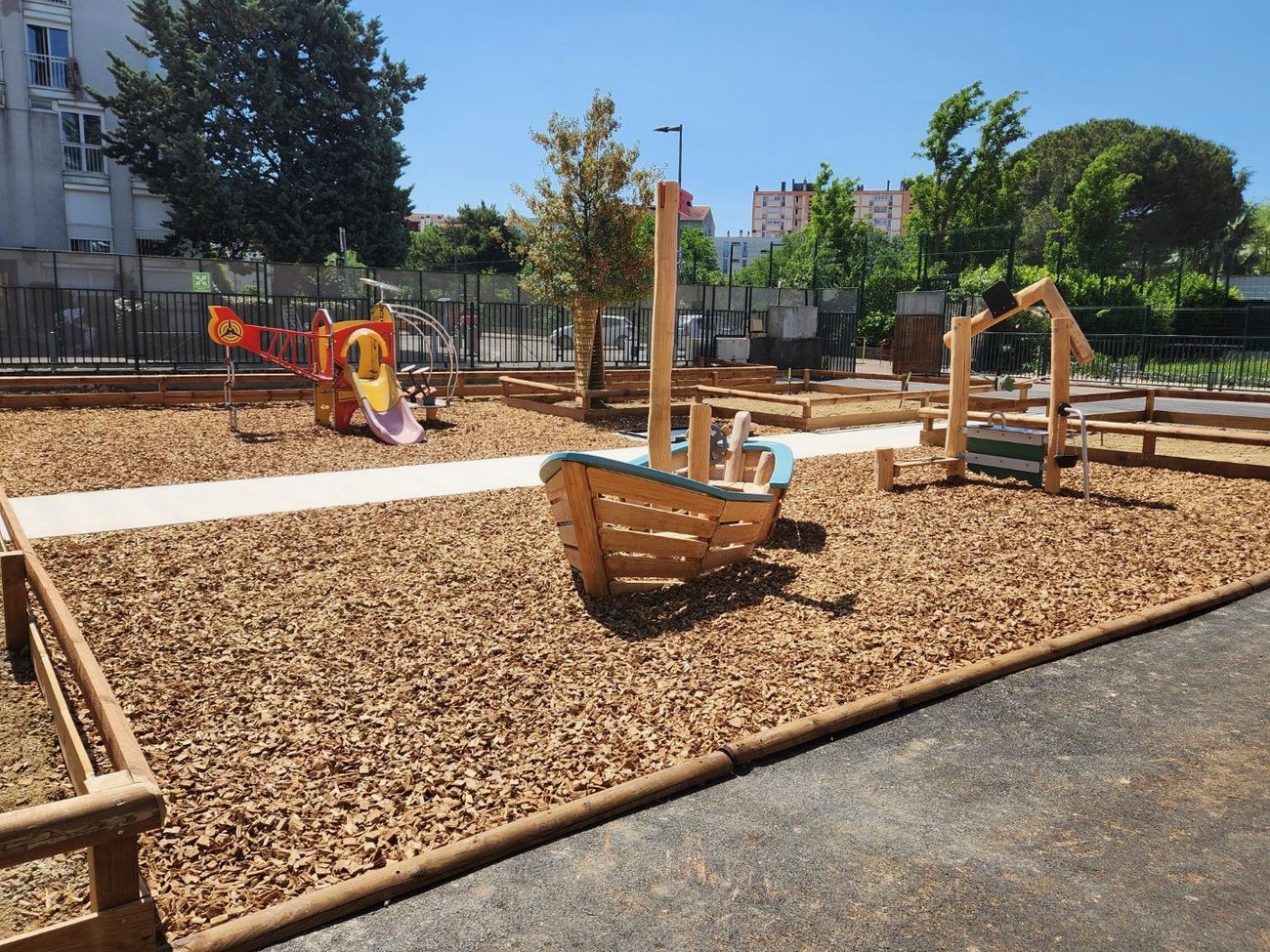 Cour oasis en Occitanie avec jeux Kompan et Vinci Play sur la même aire